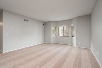 Carpeted Living Room With Large Bay Windows